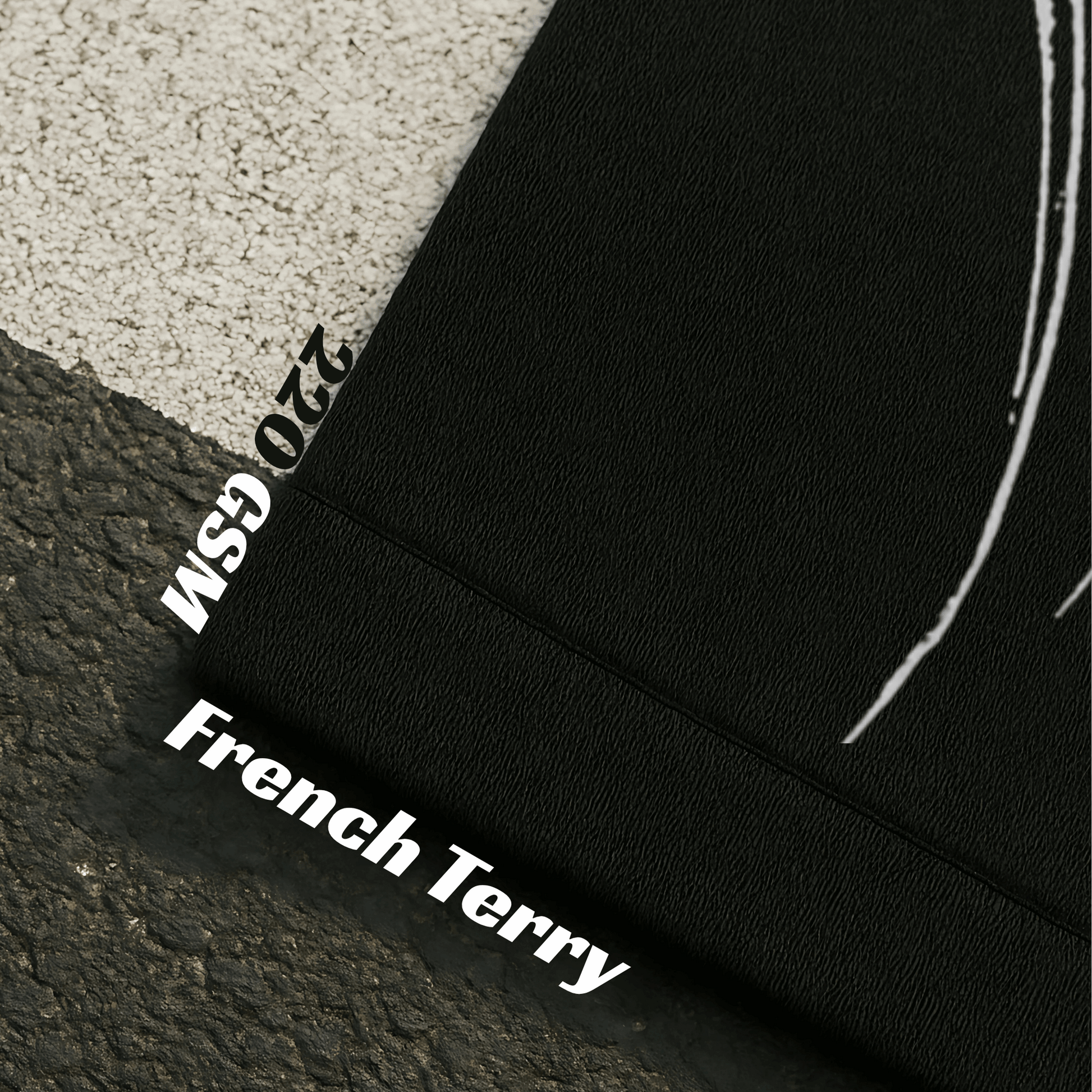 Close-up of black fabric with '220 GSM' and 'French Terry' text on a textured surface.