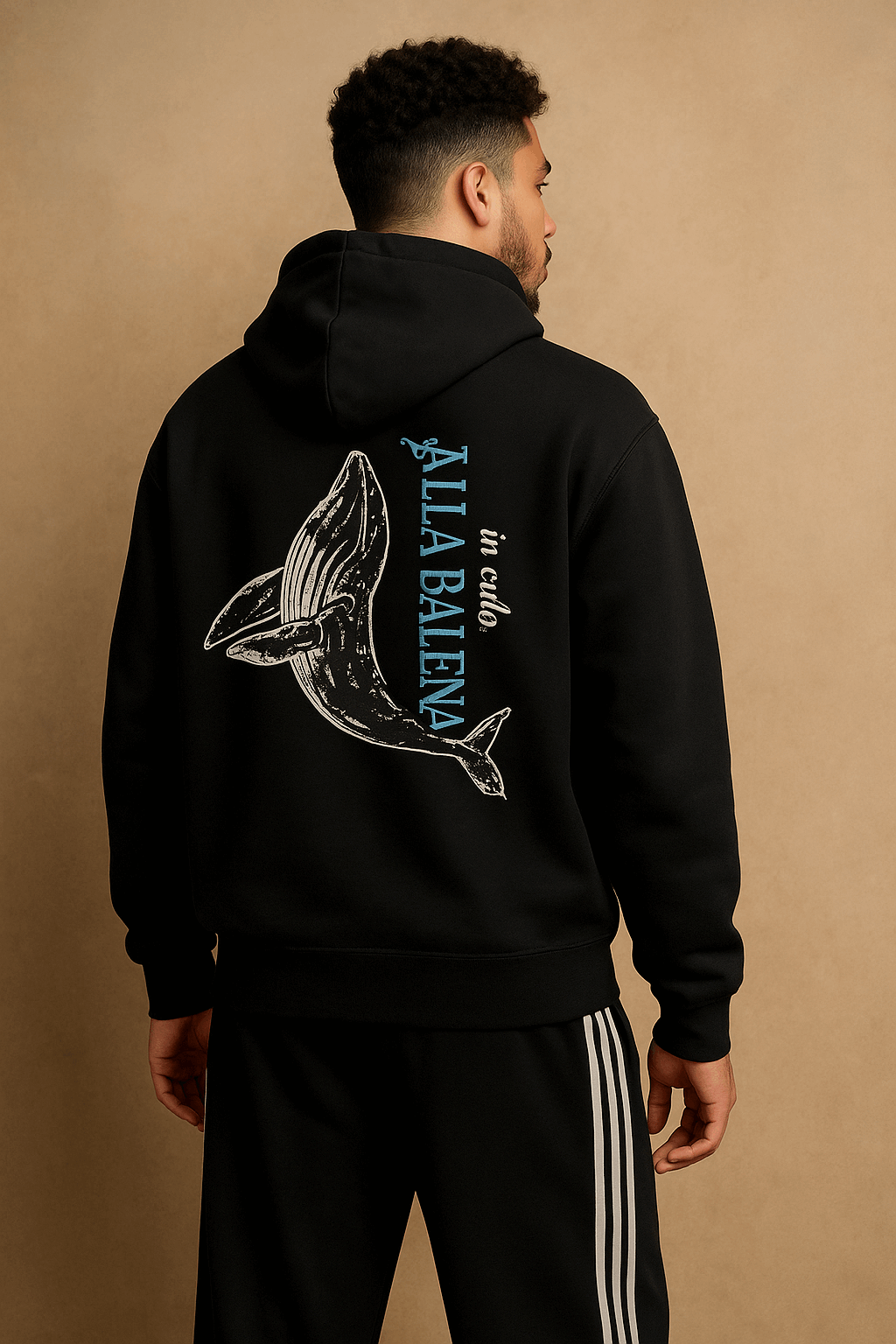 Person wearing a black hoodie with a whale graphic and 'ALLABALLENA' text on the back against a beige background