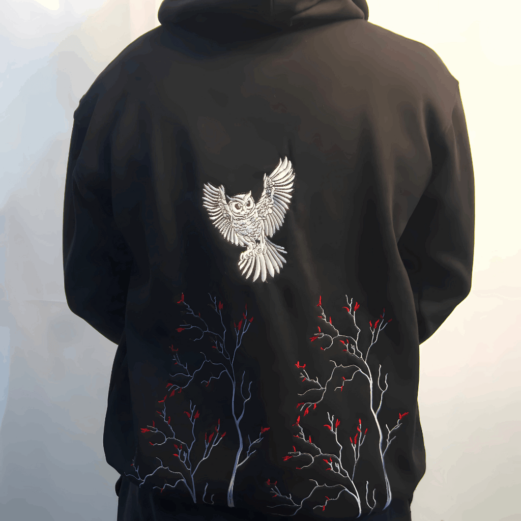 Black hoodie with white owl design on the back against a white background