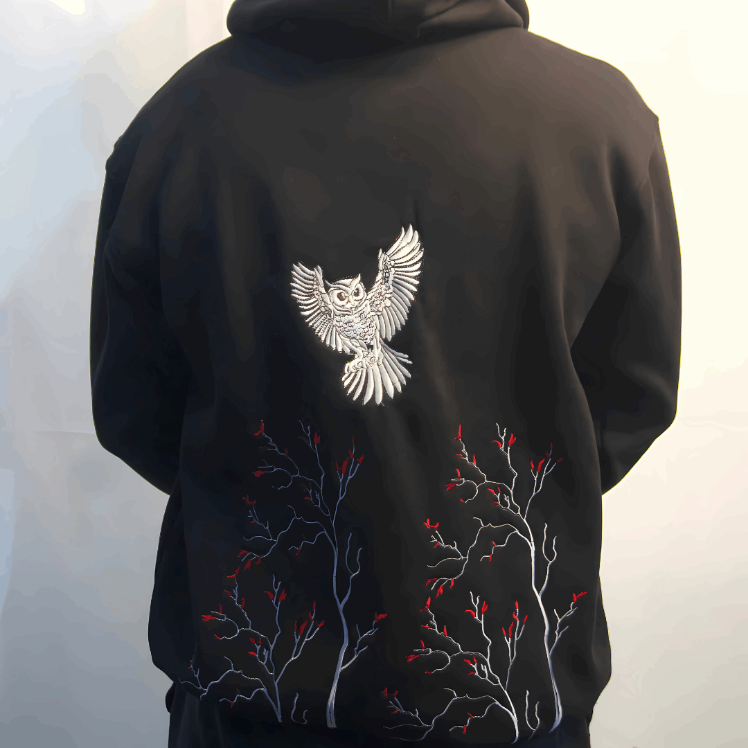 Black hoodie with white owl design on the back against a white background